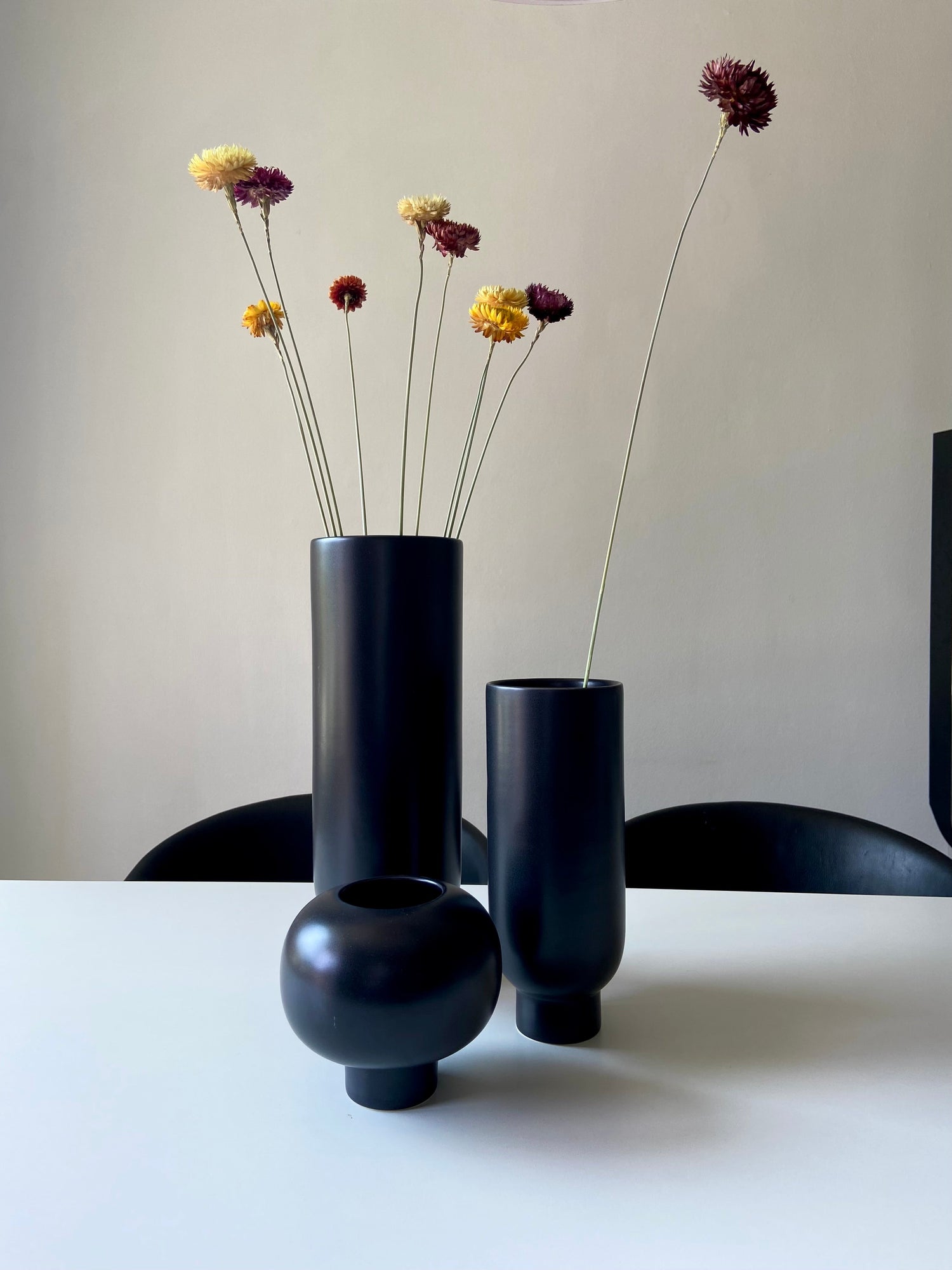 Vaser HÖJD och VALV i svart – skulpturala former med torkade blommor på bord