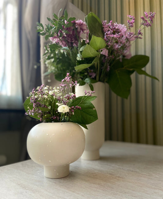 Färska snittblommor i beige vaser, stilren skandninavisk design.